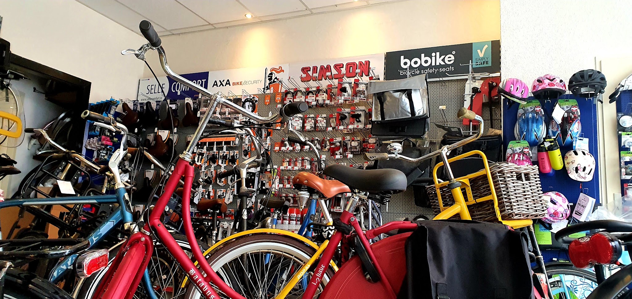 De accessoirewand bij Just Bike met zadels, sloten, helmen en fietstassen